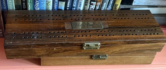 several wooden cribbage boards, stacked one on top of another